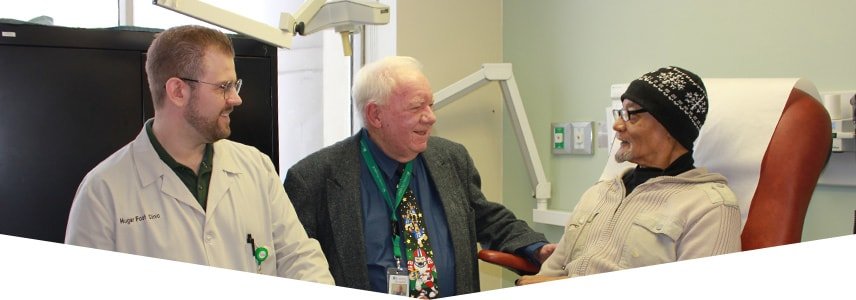 Two doctors helping an elderly patient